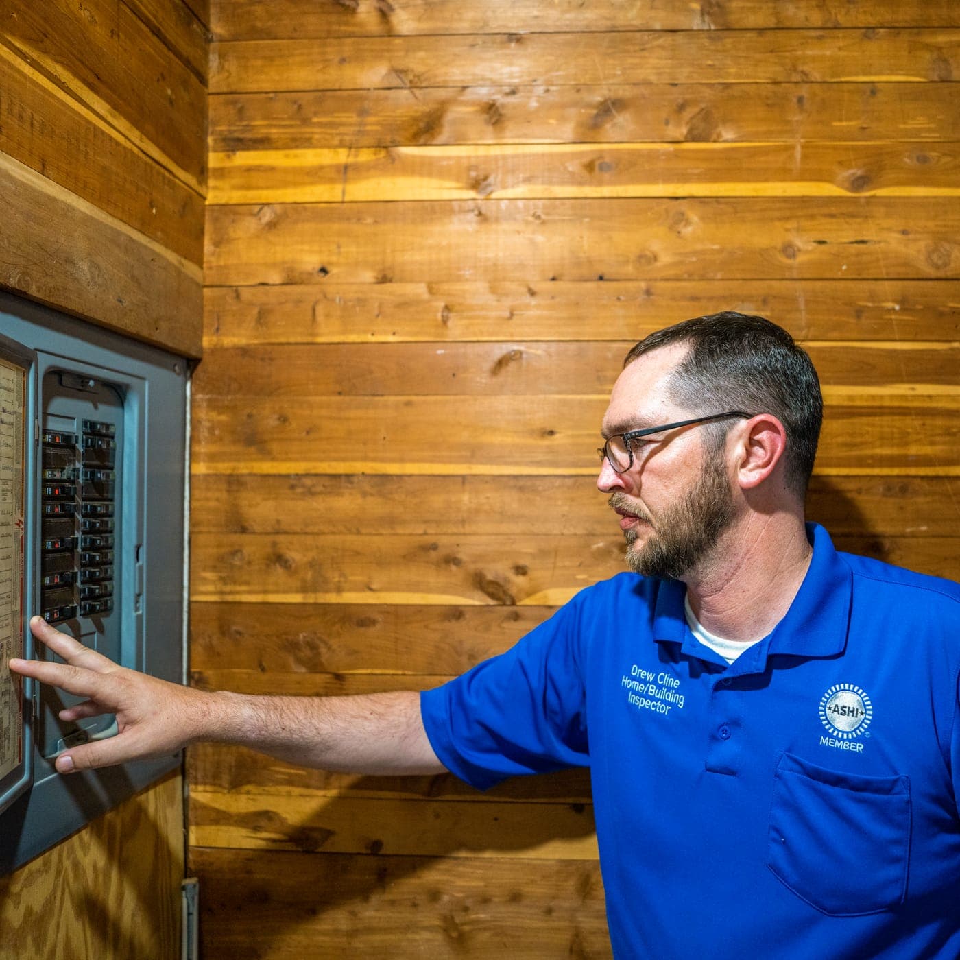 Drew Cline checking breakers at an interior electrical panel